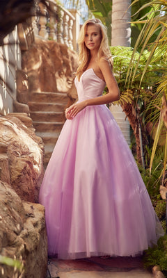 A woman wearing the Strapless Sweetheart Long Prom Ball Gown 265 with a corset-style back stands outdoors by stone steps and tropical plants, her lavender dress flowing gracefully.