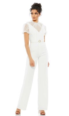 Woman wearing the Long Formal Jumpsuit 26621 by Mac Duggal with a high neck, sheer short sleeves, belted waist, and nude heeled sandals, standing against a plain white background.