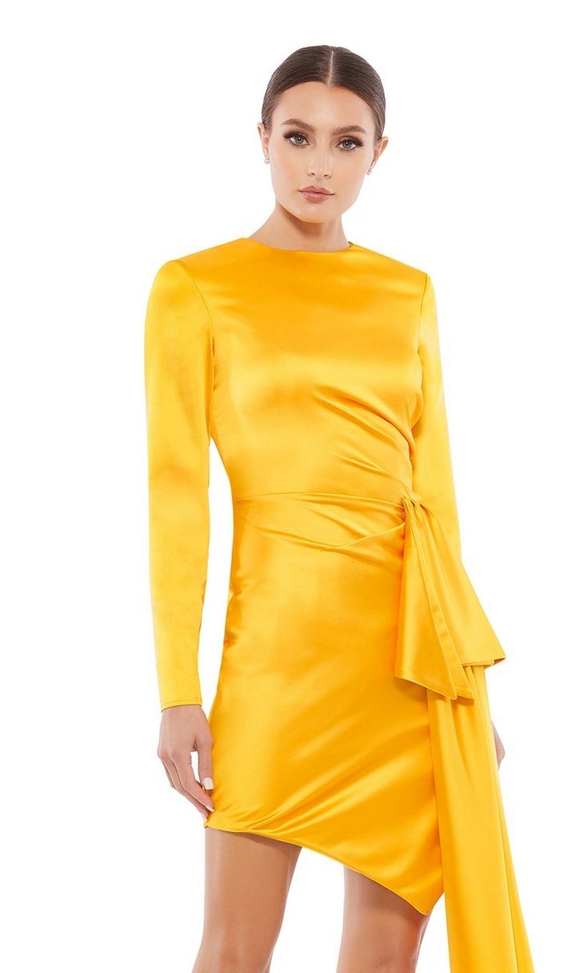 A woman stands against a plain white background wearing the Yellow Cocktail Party Dress 70152 by Mac Duggal, featuring marigold yellow color, long sleeves, an asymmetrical hem, and draped side detail.
