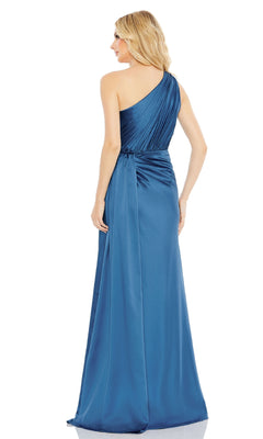 A woman with long, wavy blonde hair faces away, wearing the Mac Duggal 26654 one-shoulder long formal dress in blue satin, featuring draped detailing.