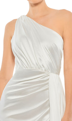 A woman in the Mac Duggal 26654 one-shoulder long formal dress, featuring white satin with ruched detailing and a draped waist, channels Grecian elegance.