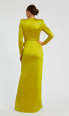 A person stands facing away, wearing the Mac Duggal 26676 Bold-Shoulder Long Formal Dress in yellow-green, featuring a bra-friendly fitted silhouette, high neckline, and floor-length elegance.