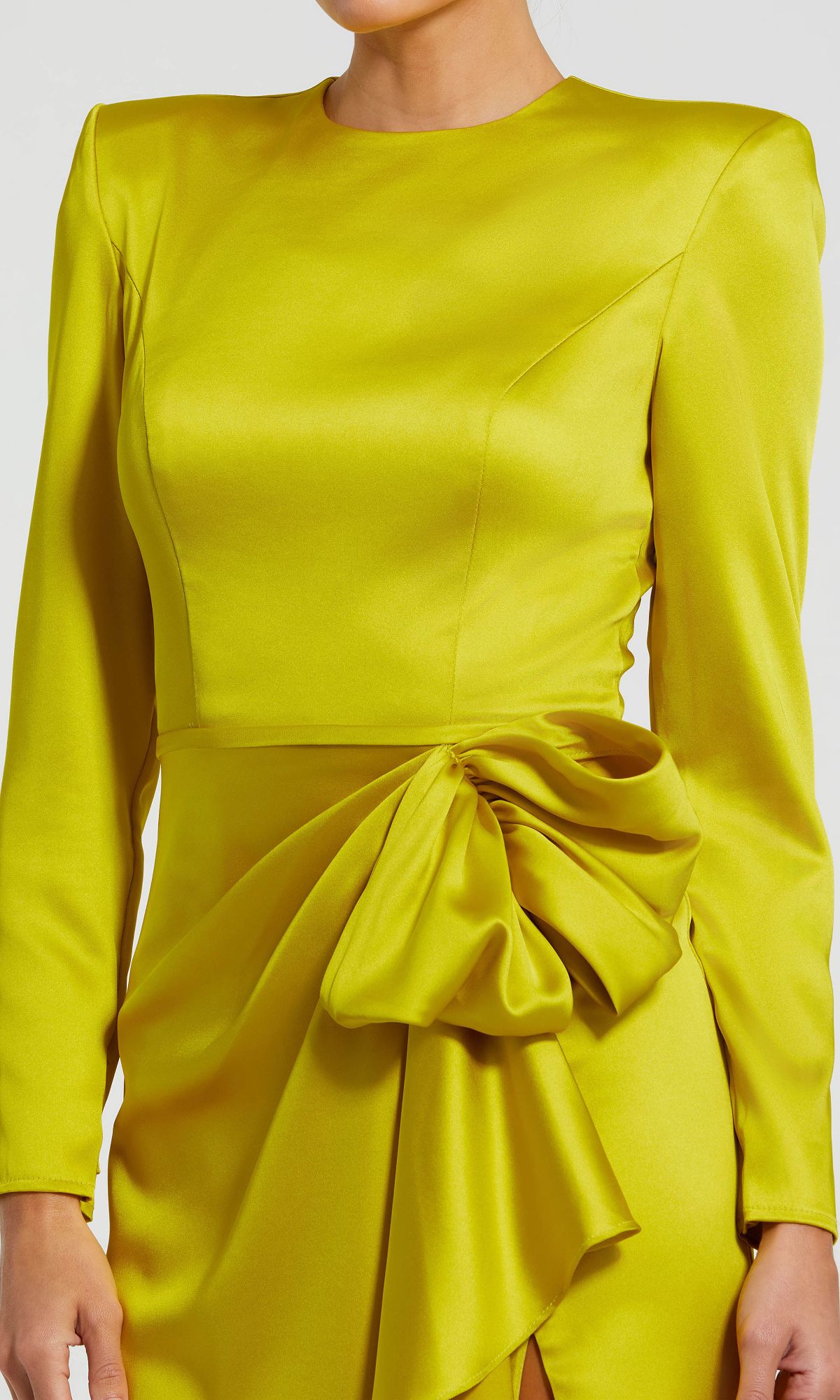 A woman wears the Mac Duggal 26676 Bold-Shoulder Long Formal Dress in bright yellow satin, designed with bra-friendly long sleeves and a dramatic structured bow at the waist.