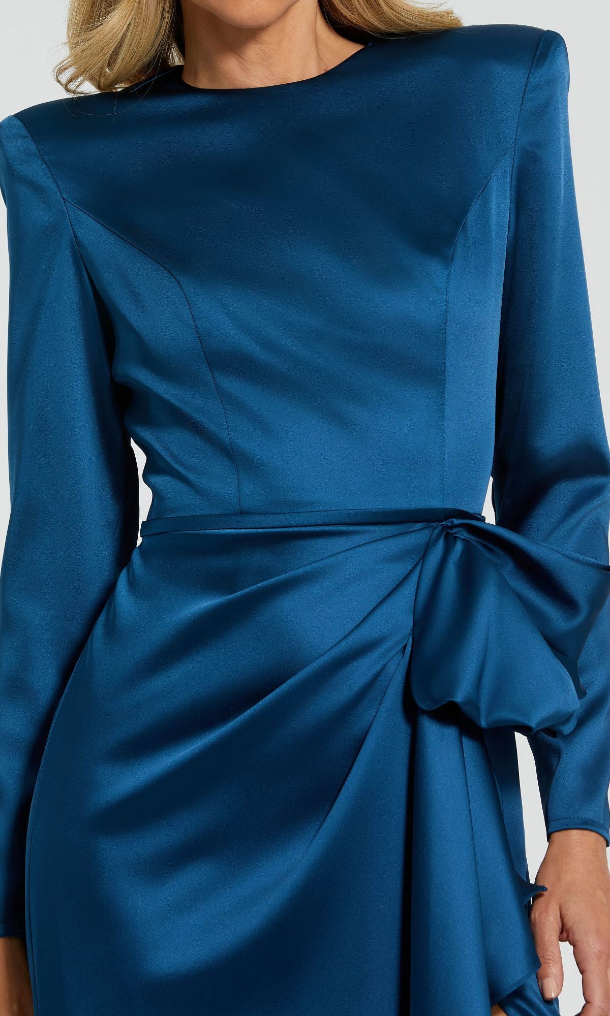 A person wearing the Mac Duggal 26676 Bold-Shoulder Long Formal Dress in blue satin, featuring bra-friendly design, structured shoulders, and a large waist bow—ideal as a chic evening gown.