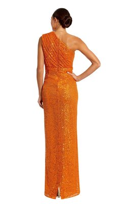 A woman faces away from the camera, wearing the Mac Duggal 26694 one-shoulder long formal dress in orange sequins, with her hair styled in a neat bun.