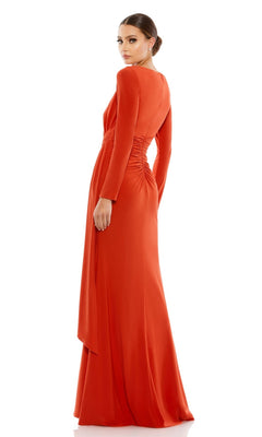 A woman faces away wearing the Long Formal Dress 26714 by Mac Duggal, an orange, floor-length gown with long sleeves, elegant waist ruching, and a smooth, flowing skirt.