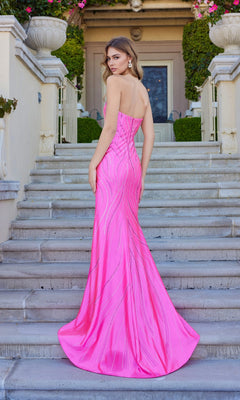 Wearing the Juliet JT2673R long prom dress in bright pink, a woman stands on outdoor stone steps, glancing over her shoulder.