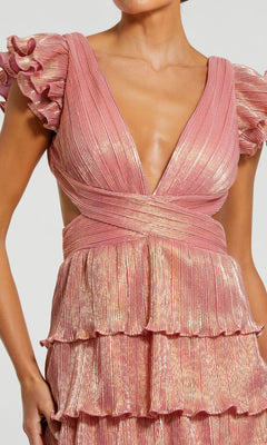 A woman wearing the Mac Duggal Open-Back Tiered Formal Dress 26740 in pink metallic, featuring flutter sleeves, a deep V-neckline, a lace-up open back, and a tiered pleated skirt.