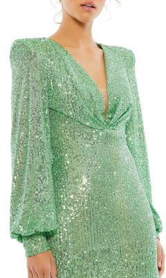 A woman wears the Mac Duggal 26865 Long Sleeve Sequin Hoco Dress—a shiny light green style with puffed sleeves and a deep V-neckline.