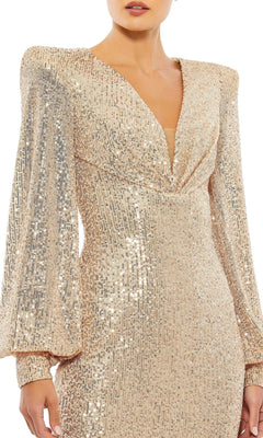 A person wearing the Mac Duggal 26865 Long Sleeve Sequin Hoco Dress, featuring gold sequins, a deep V-neckline, and gathered shoulder detailing.