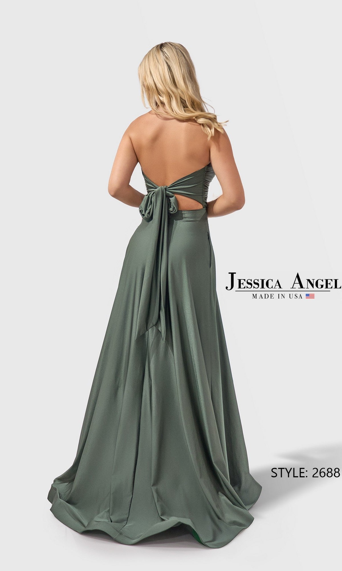 A woman with long blonde hair wears the Jessica Angel 2688, a sage green strapless satin jersey prom dress with a tied back bow and floor-length design.