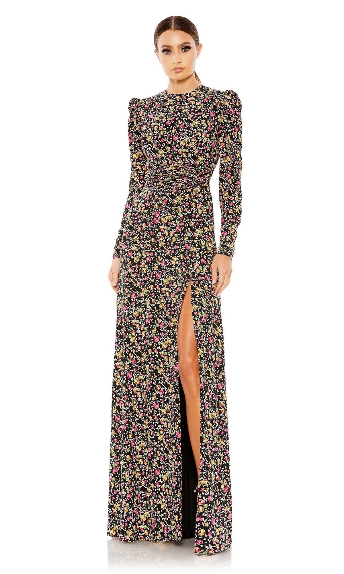 A woman models the Long Formal Dress 26916 by Mac Duggal—black with floral print, long sleeves, high neckline, and a thigh-high slit—standing against a white background.
