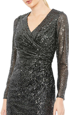 A woman wearing the Short Wedding Guest Dress 26940 by Mac Duggal, a chic black sequin knee-length party dress with long sleeves, a V-neckline, and a stylish faux wrap design.