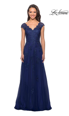 A woman stands and smiles against a white background, wearing the La Femme 26942 long formal dress in marine blue—a floor-length gown featuring floral lace, cap sleeves, a V-neckline, and delicate embroidery.