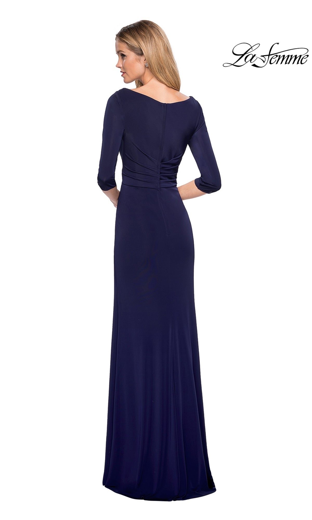 A woman stands facing away against a plain white background, wearing the Long Formal Dress: La Femme 26955. This navy evening gown features elegant long sleeves, a fitted waist, and a sheath skirt that creates a smooth, timeless silhouette.