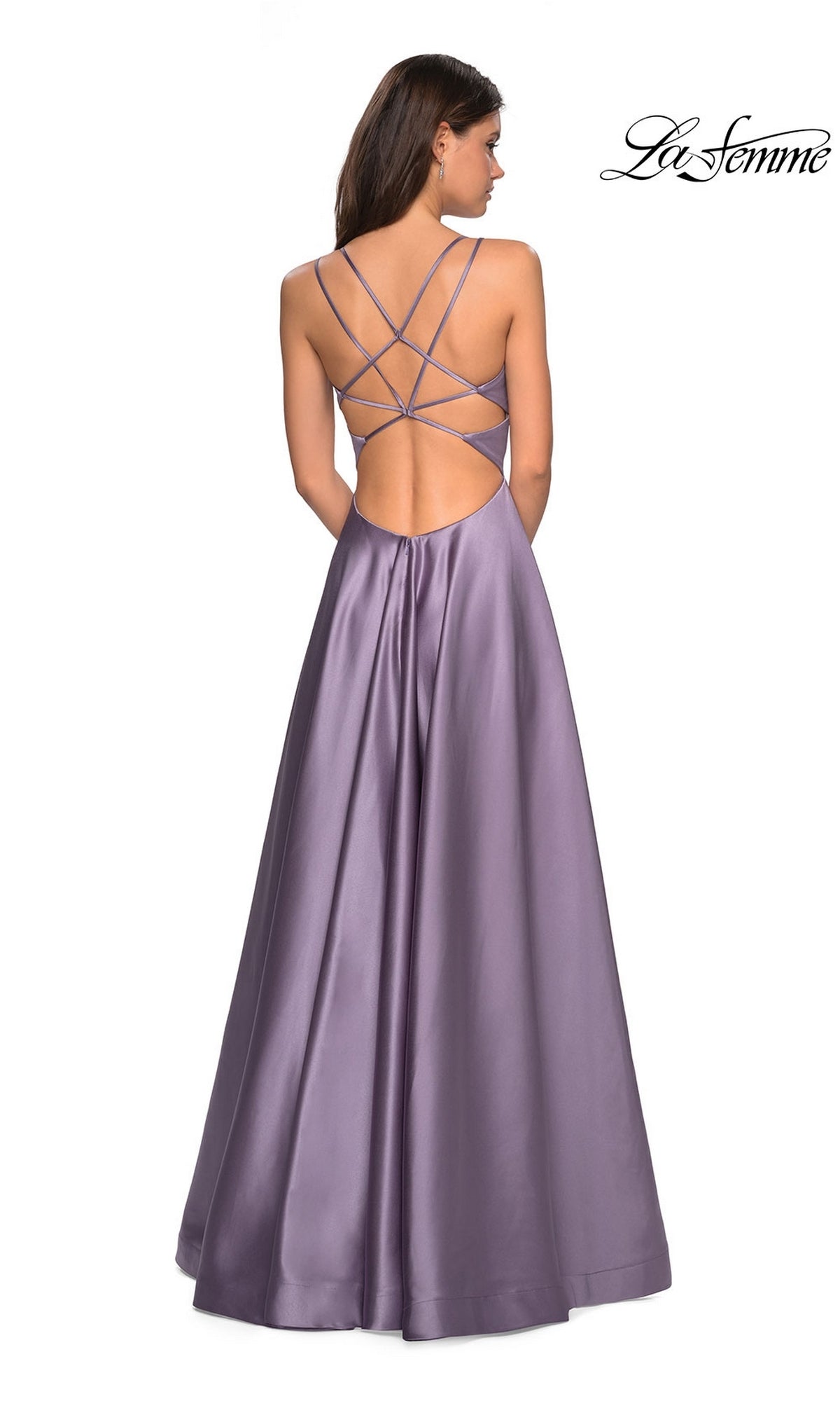 A woman faces away in the La Femme Deep V-Neck Long A-Line Prom Dress 26994, a floor-length lavender gown with a sleeveless fitted bodice and crisscross open back.