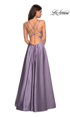 A woman faces away in the La Femme Deep V-Neck Long A-Line Prom Dress 26994, a floor-length lavender gown with a sleeveless fitted bodice and crisscross open back.