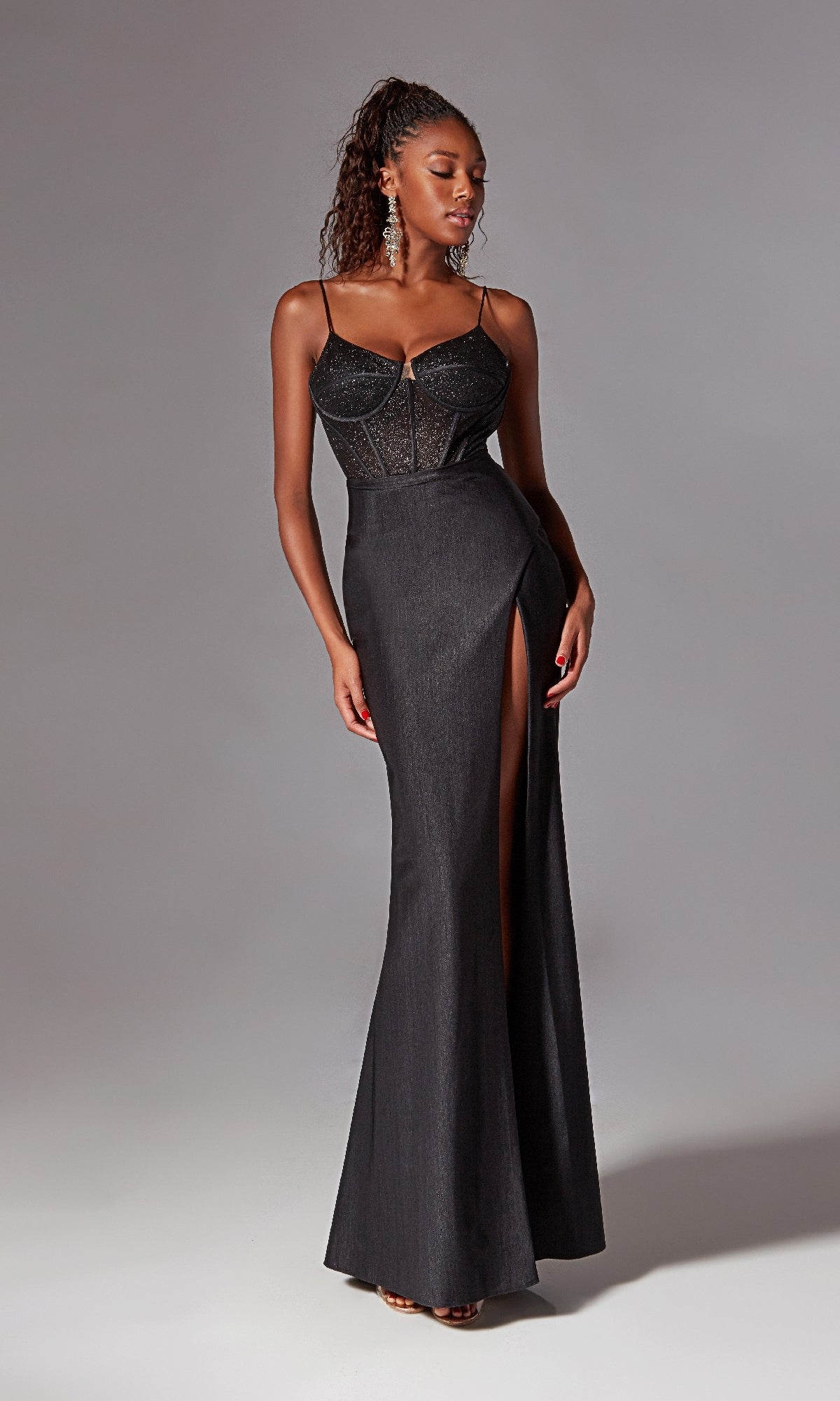 A woman models the Corset-Bodice Long Prom Dress: Aerie Couture 269—a fitted, sleeveless black glitter evening gown with thin straps, sheer bodice, and high slit—against a plain light gray background.