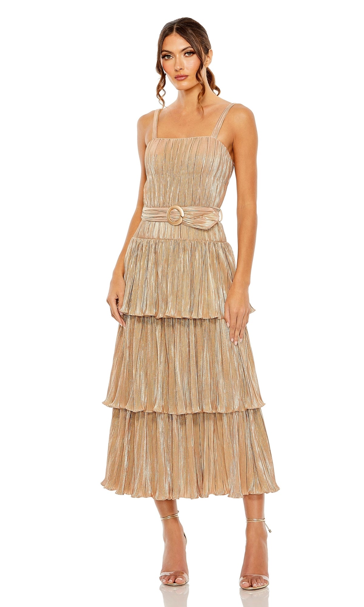 A woman stands against a plain white background in strappy heels, wearing the Mac Duggal Tea-Length Metallic Party Dress 27062, which features tiered pleats, thin straps, and a belt.