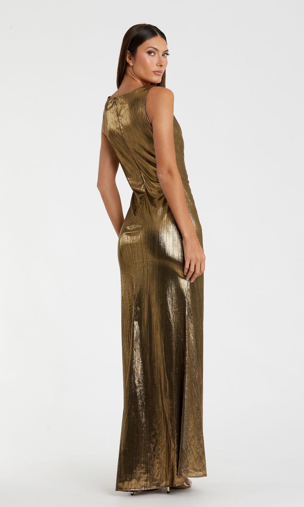 A woman faces away, head turned slightly toward the camera, modeling the Long Gold Metallic Formal Dress: Mac Duggal 27063 and showcasing its elegant evening style.