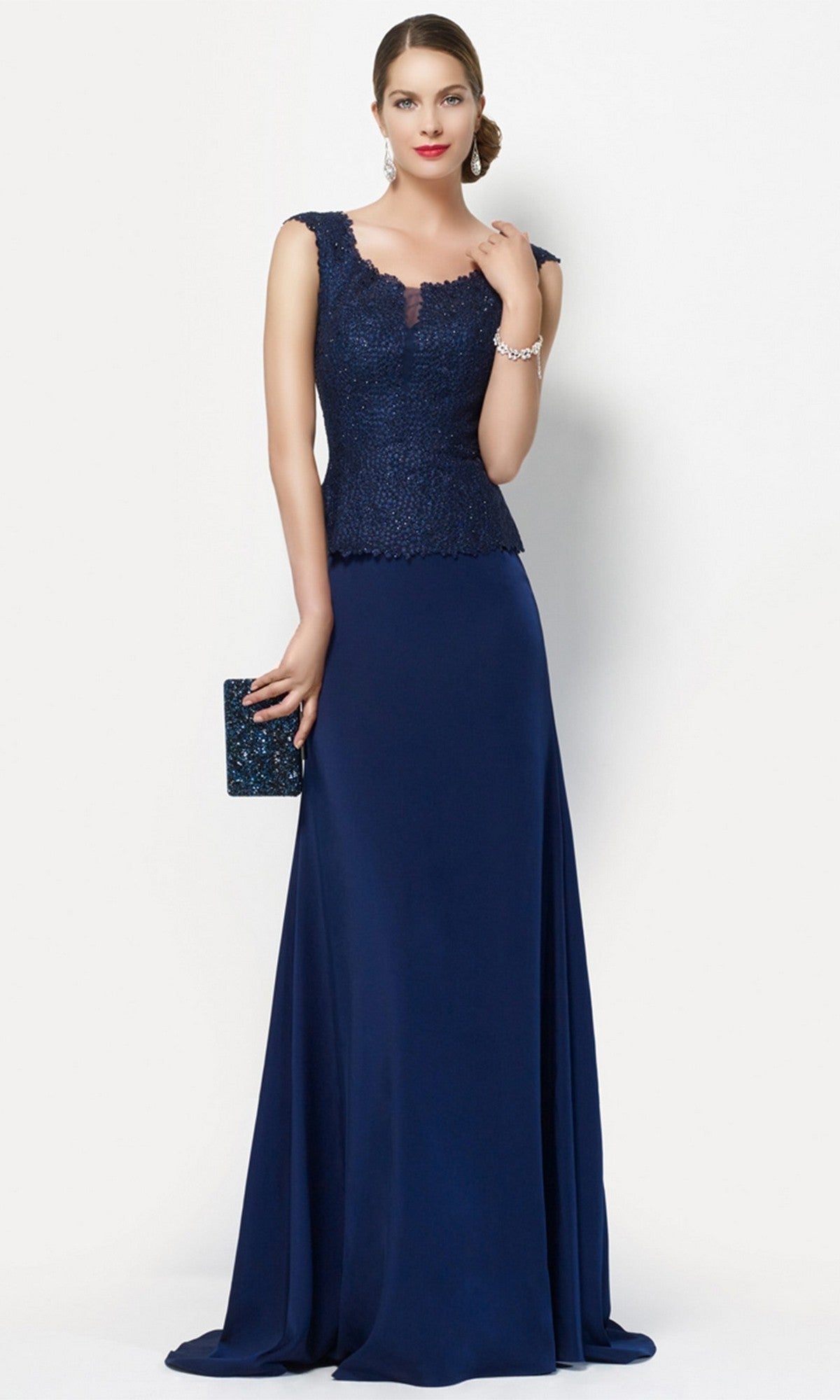 A woman stands against a plain light background wearing the Alyce 27105 long formal navy dress with a sleeveless lace bodice, holding a dark clutch.
