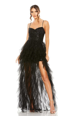 A woman confidently poses in the Mac Duggal 27119 Overskirt Mini Sequin Prom Dress, featuring thin straps, a sleeveless black sequin bodice, and a sheer layered high-low skirt.