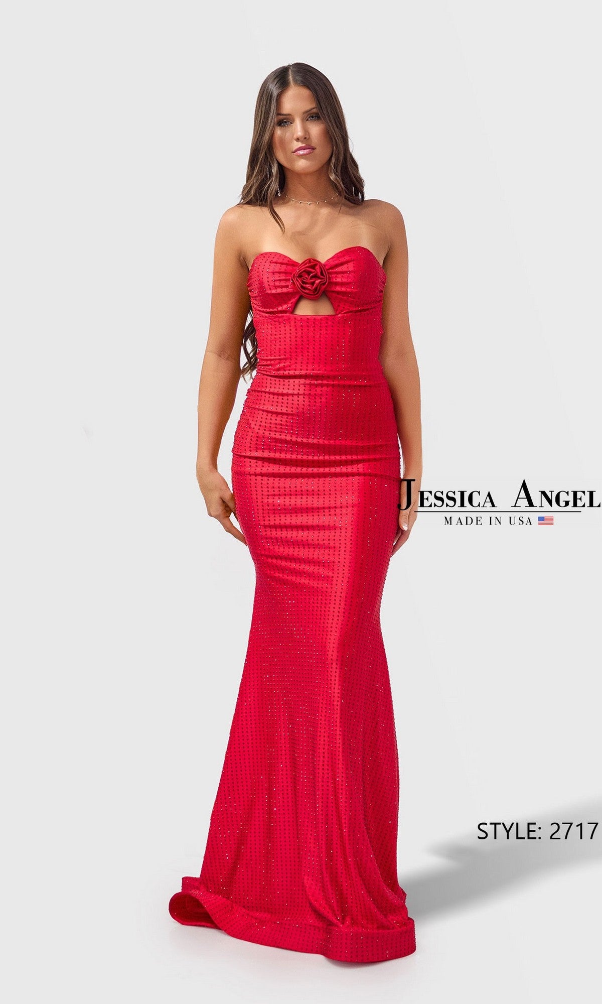 A woman in the Jessica Angel 2717 long prom dress in J Red, featuring a strapless sweetheart neckline and rose detail at the bust, stands against a plain background.