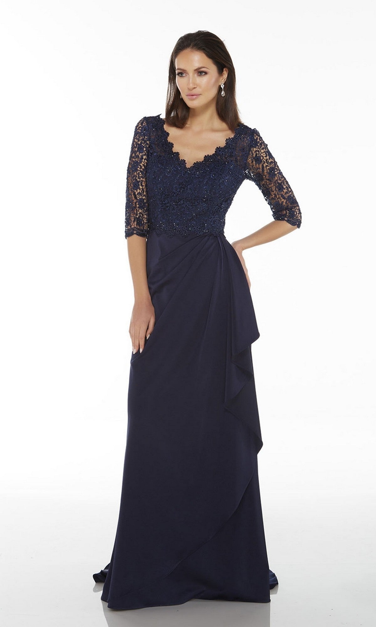 A woman models the Alyce 27242 long formal dress—navy blue with a beaded lace bodice, three-quarter sleeves, and a floor-length skirt—posed against a plain white background.