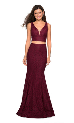 A woman smiles against a white background wearing the La Femme Two-Piece Mermaid Lace Prom Dress 27262, a sleeveless deep burgundy gown with a fitted mermaid silhouette.