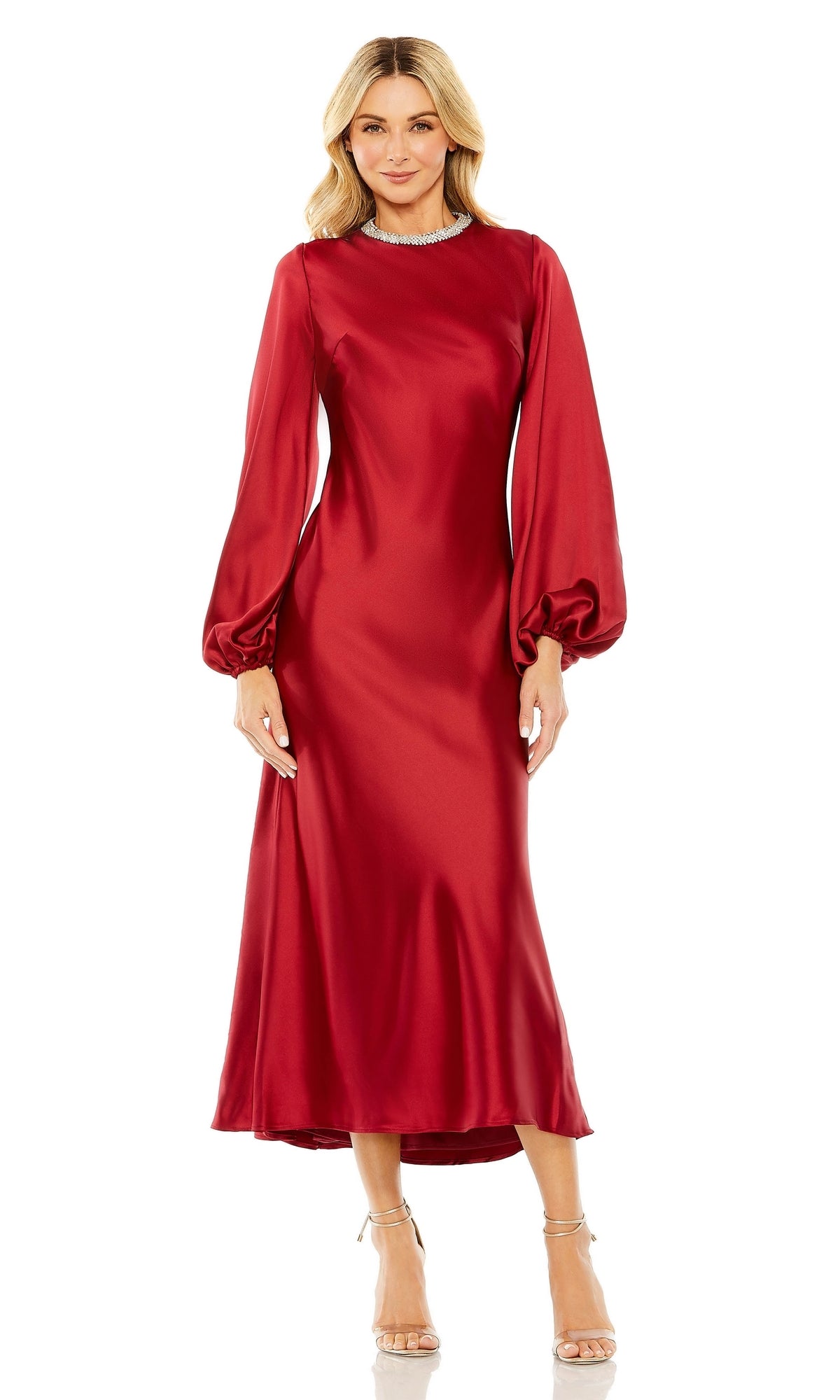 A woman wearing the Mac Duggal 27350 Modest Midi Wedding Guest Dress with long sleeves, a beaded high neckline, red satin fabric, and paired with strappy high-heeled sandals.