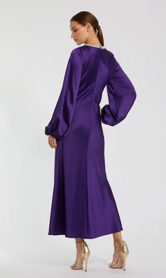 Woman in the Modest Midi Wedding Guest Dress: Mac Duggal 27350, featuring long puffed sleeves, a beaded high neckline, and fitted waist, stands in heels facing away from the camera.