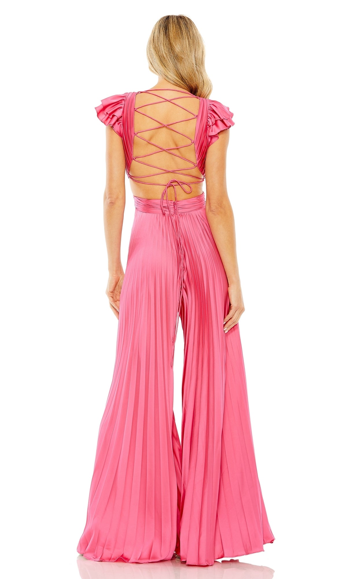 A woman faces away from the camera, wearing the Pleated Formal Jumpsuit 27361 by Mac Duggal, featuring bright pink pleats, wide legs, short ruffle sleeves, a v-neckline, and a lace-up open back.