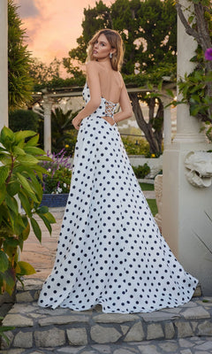 A woman stands outdoors on stone steps, looking over her shoulder in the Juliet JT2740S Long Prom Dress—a strapless vintage polka dot gown with a sweetheart neckline and flowing A-line skirt.