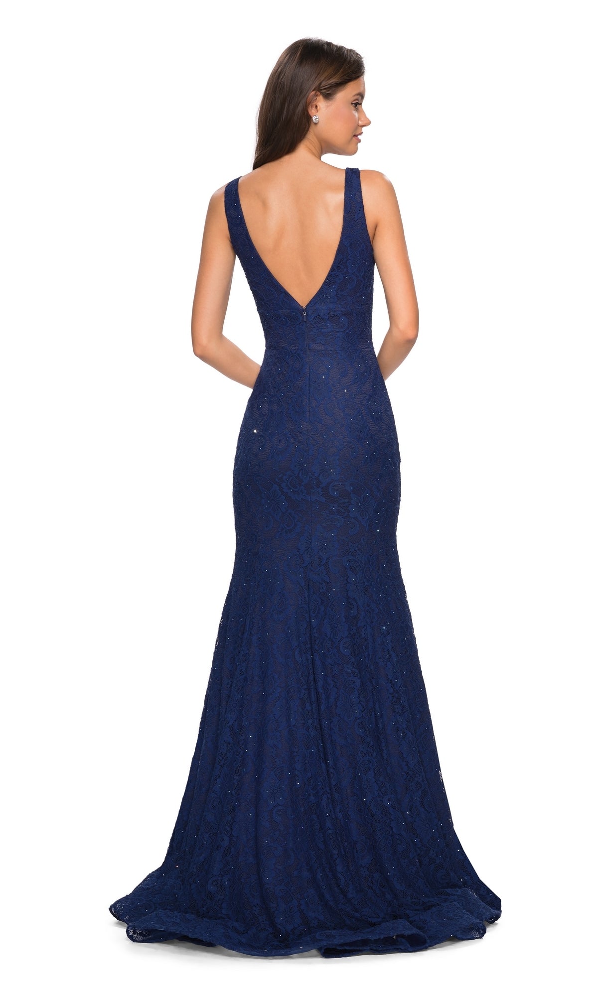 A woman models the La Femme 27464 V-Neck Lace Mermaid Prom Dress—sleeveless, floor-length, dark blue with a deep V-back—standing and facing away from the camera.
