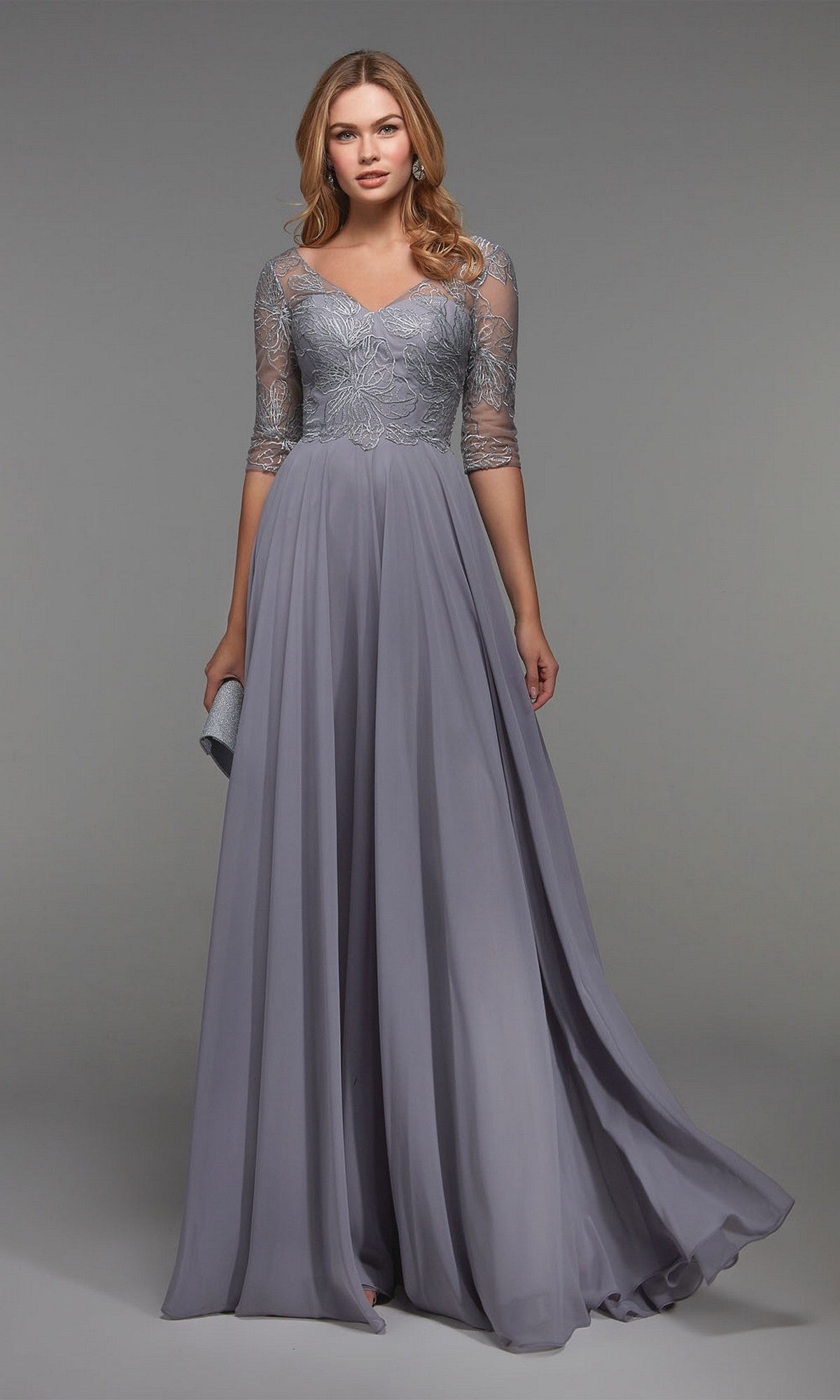A woman models the Alyce 27475 long formal dress in grey, featuring lace sleeves and a fitted bodice, against a plain grey background.