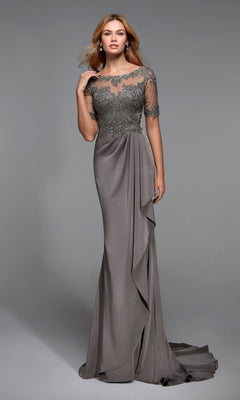A woman wears the Alyce 27477 long formal dress in Stone, featuring an embellished bodice, lace details, and sheer short sleeves, standing against a plain gray background.