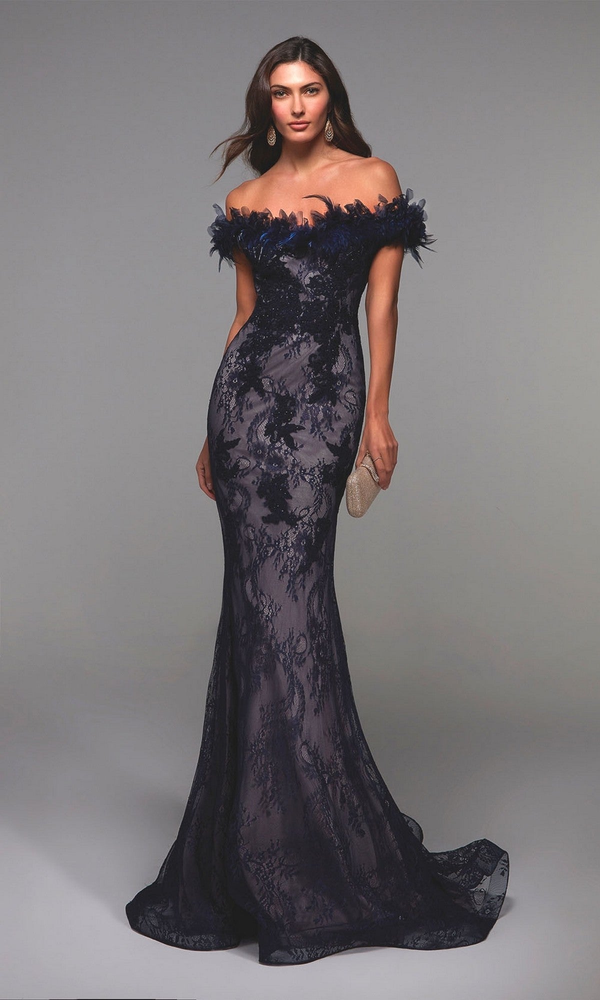 Woman wearing the Alyce 27490 long formal dress in navy/latte, featuring an off-shoulder, fitted mermaid silhouette with floral lace detail, holding a beige clutch against a plain gray background.
