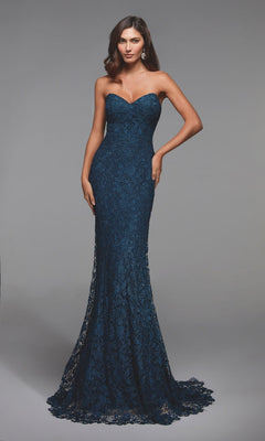 A woman stands against a plain gray background wearing the Alyce 27496, a navy blue, floor-length mermaid formal dress with a strapless neckline and shimmering lace.
