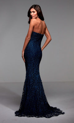 A woman faces away in the Alyce 27496 long formal dress, featuring a strapless neckline, curve-hugging dark blue mermaid silhouette, shimmering lace back detail, and floor-length train against a plain background.