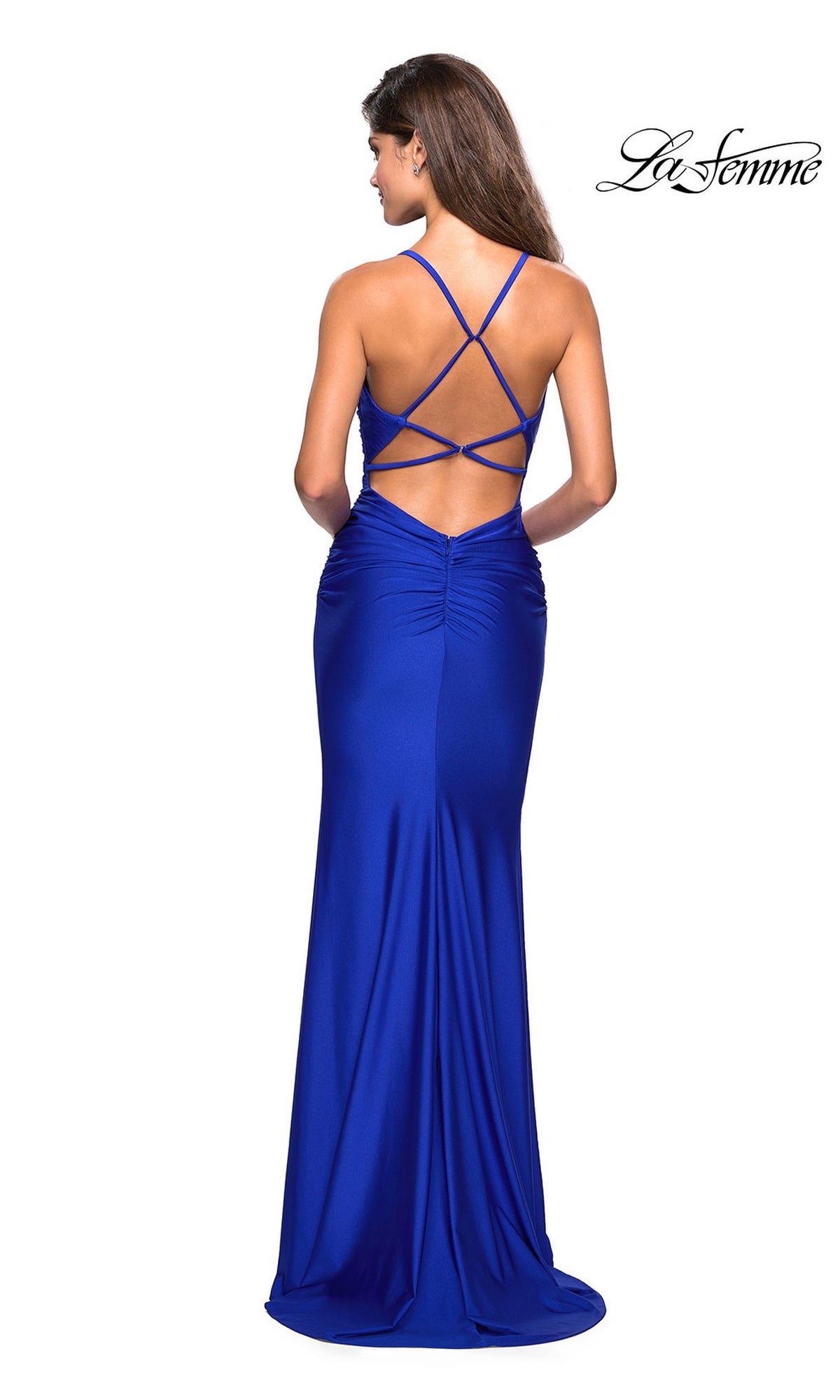 Woman in a floor-length, fitted royal blue La Femme Cowl-Neck Long Prom Dress 27501 with crisscross open-back straps, standing and facing away from the camera. 