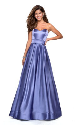 A woman poses against a white background wearing the Strapless A-Line Satin Prom Dress: La Femme 27506, a lavender gown with a fitted bodice and flared skirt.