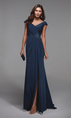 Woman in the Alyce 27508 long formal dress in Blue Opal with cap sleeves, v-neckline, and beaded waist detail, paired with a black clutch and strappy heels—an elegant choice for a mother-of-the-bride.