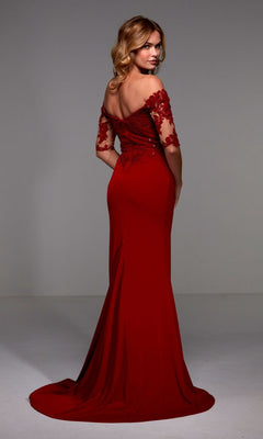 A woman in the Alyce 27518 long formal dress, featuring a red off-the-shoulder sequin lace bodice and sheath crepe floor-length skirt, stands facing backward and looks over her shoulder.