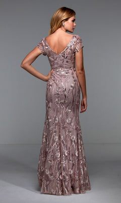 Woman models the Alyce 27533 long formal dress, featuring short sleeves, a floor-length sheath silhouette, and mauve floral lace—ideal for mother-of-the-bride occasions. Shown from the back in a simple studio setting.