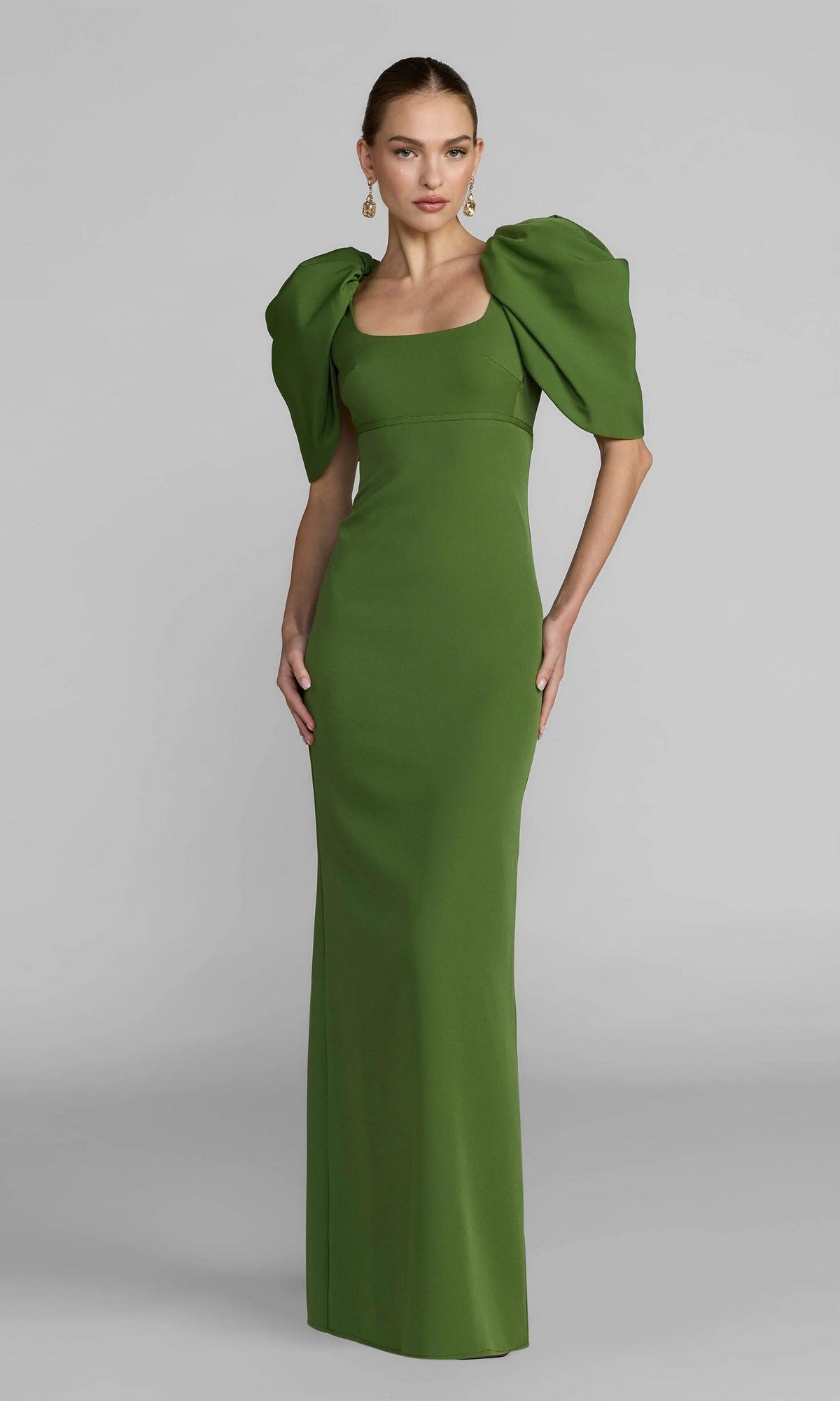 A woman wearing the Mac Duggal 27534 Puff-Sleeve Long Formal Dress in green stands against a plain light gray background.