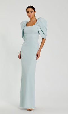 Woman in a light blue Puff-Sleeve Long Formal Dress, Mac Duggal 27534, featuring structured puff sleeves, posed against a plain white background.