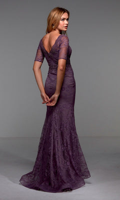 A woman stands slightly turned, modeling the Alyce 27536 long formal dress—a fitted purple lace gown with a fit-and-flare silhouette, short sleeves, and a V-shaped back.