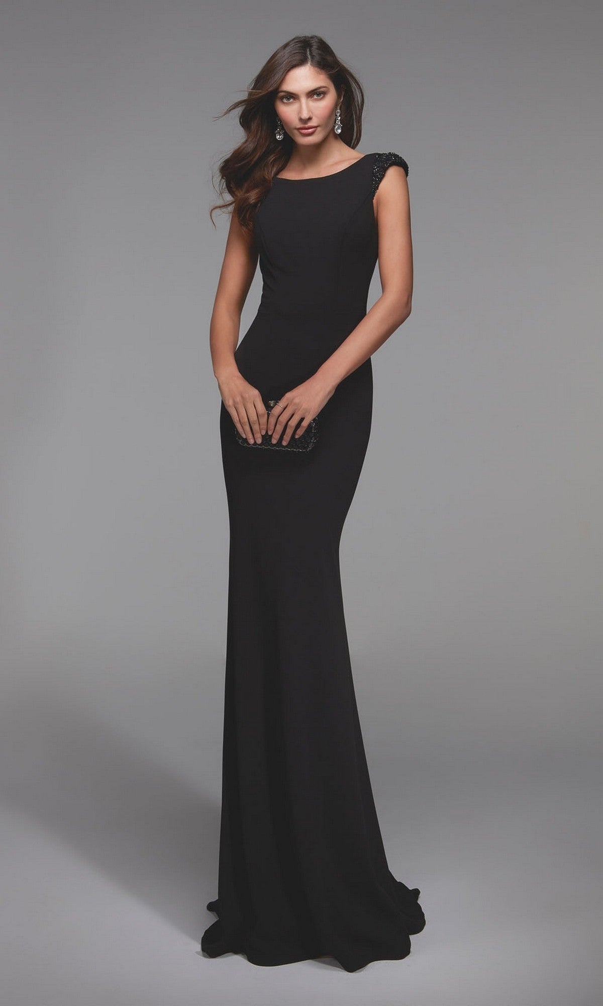 A woman wearing the Alyce 27539 long formal dress, a floor-length, sleeveless jersey gown, holds a small clutch while standing against a plain gray background.
