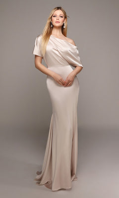 A woman stands against a plain background wearing the Alyce 27560 long formal dress in light latte, featuring an off-the-shoulder satin design and a floor-length silhouette.