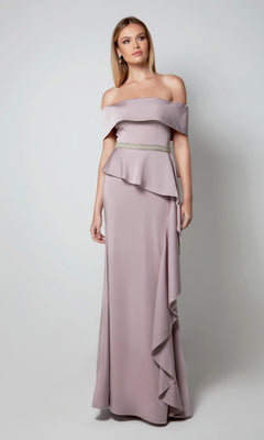 A woman in the Alyce 27563 long formal dress in soft heather, featuring off-the-shoulder styling, a ruffled peplum, and beaded waist detail, stands against a plain light background—ideal for a stylish mother-of-the-bride look.